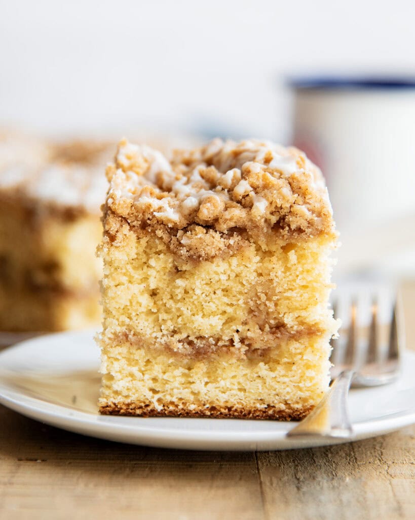 A piece of cinnamon swirl coffee cake on a plate next to a fork.