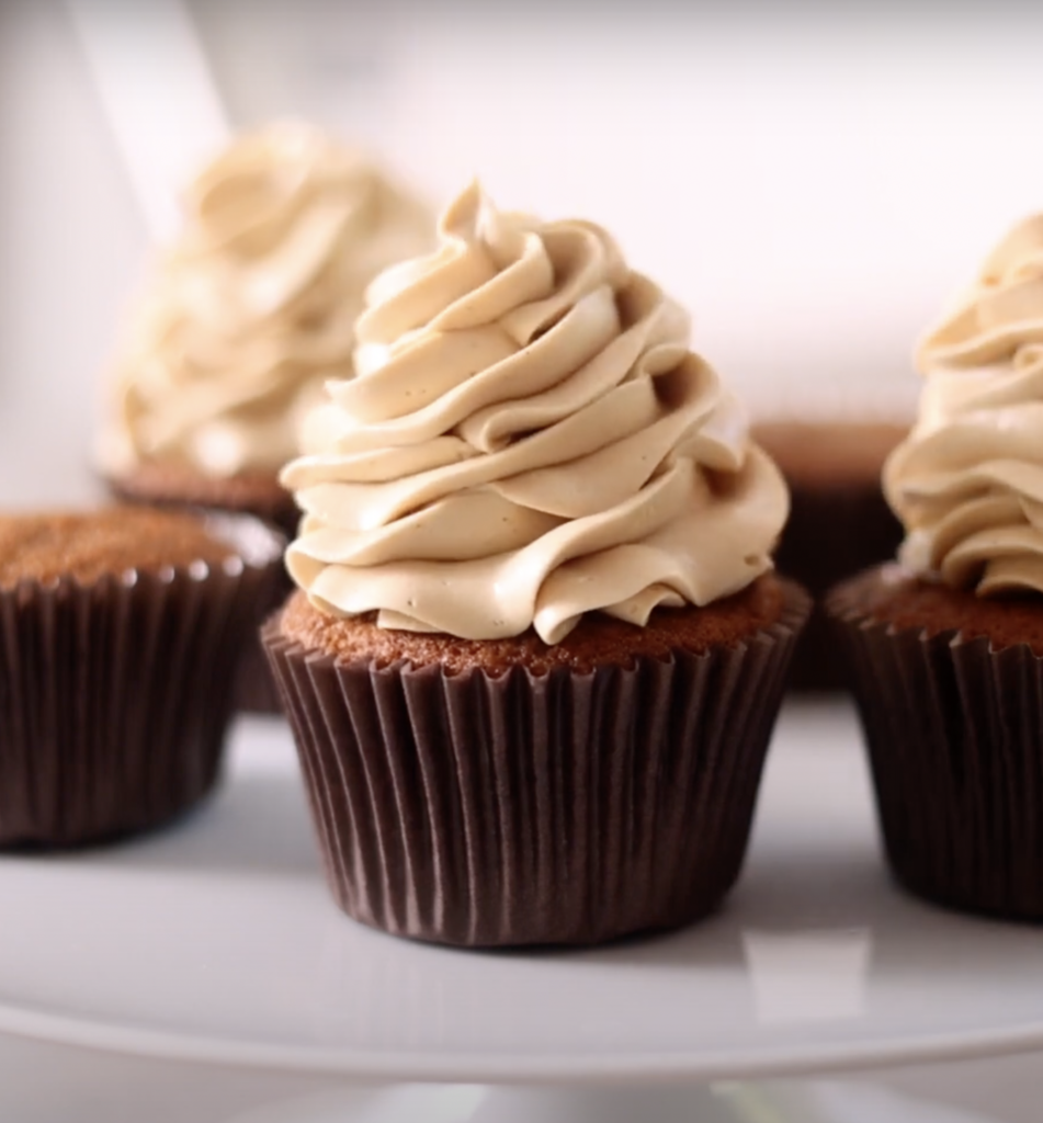 A cupcake with a brown wrapper and topped with Russian Buttercream. 