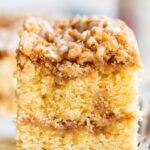 A piece of cinnamon swirl coffee cake on a plate next to a fork.