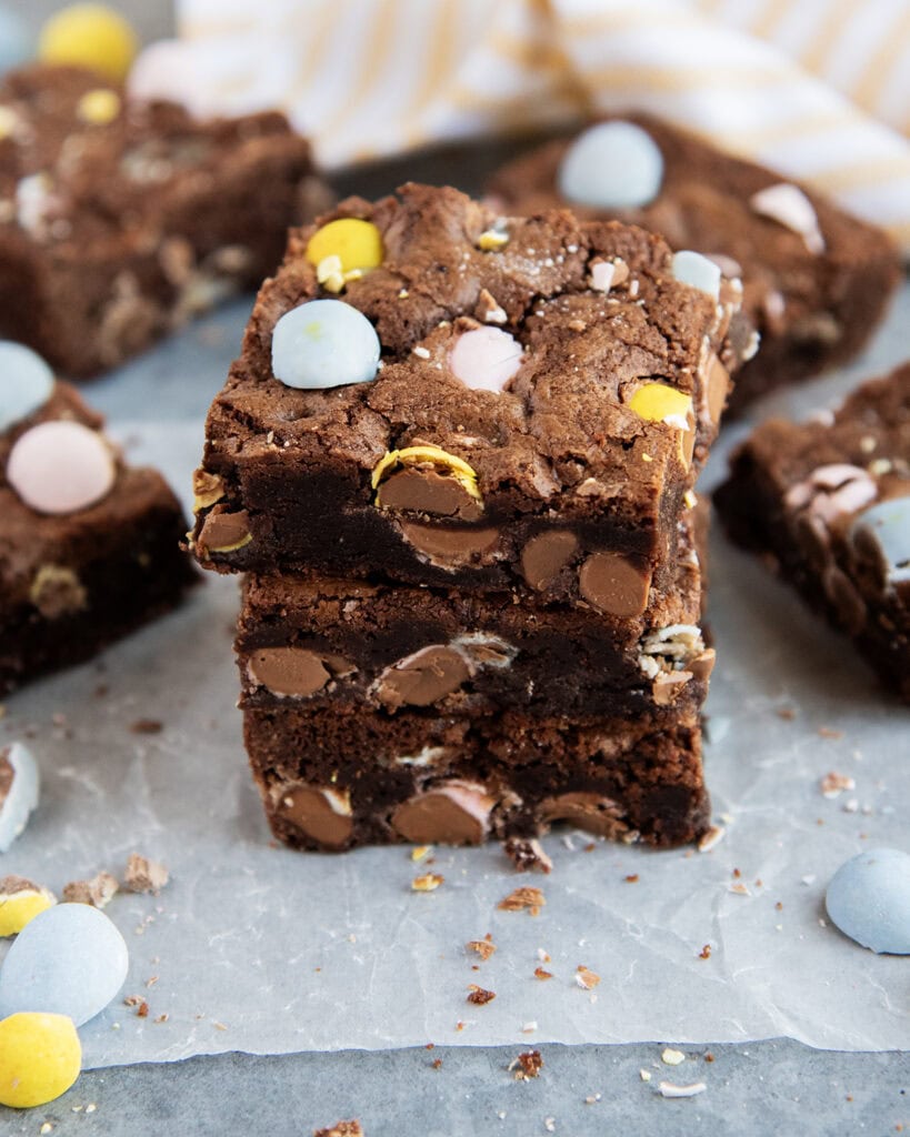 A stack of three brownies full of cadbury mini eggs.