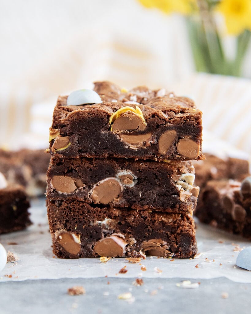 A stack of three brownies full of cadbury mini eggs.