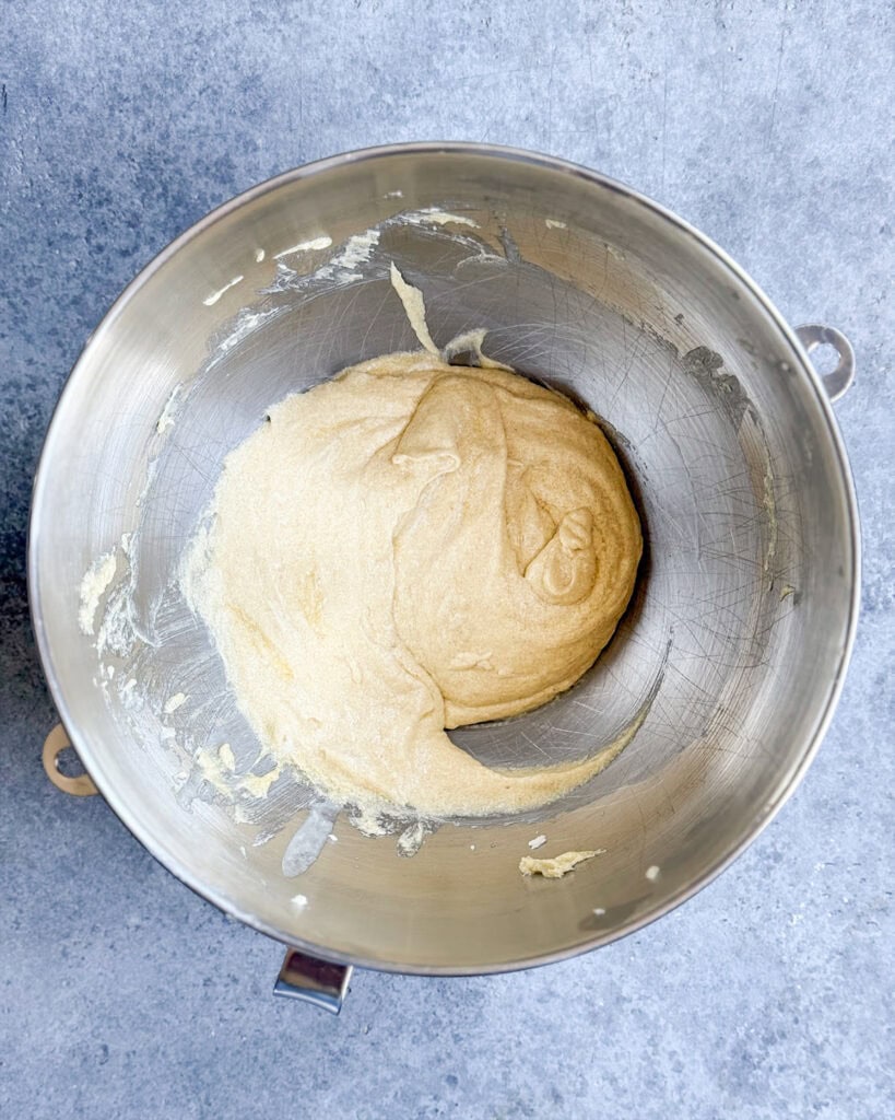 Creamed butter, sugar, and eggs in a metal mixing bowl.