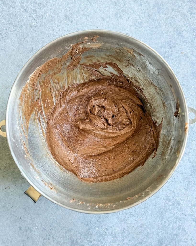 Brownie batter in a metal mixing bowl.