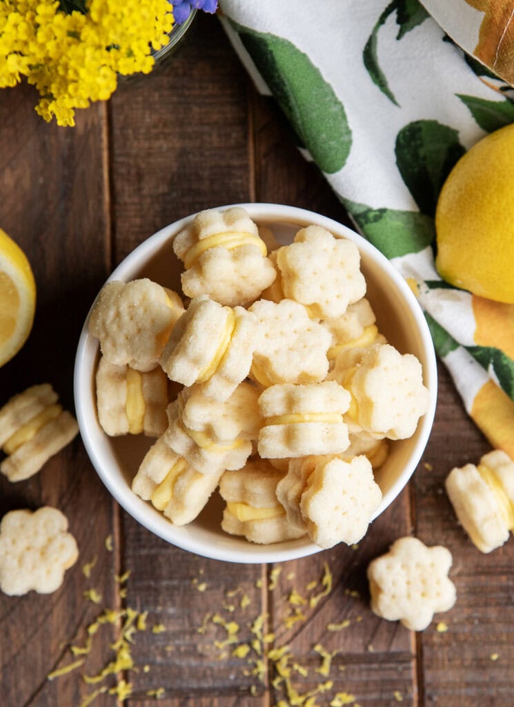 A bowl of lemon flower cookie sandwiches.