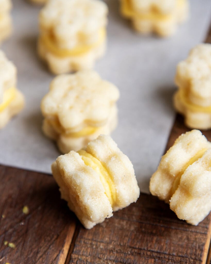 Tiny lemon cream wafer cookies shaped like flowers on their side.