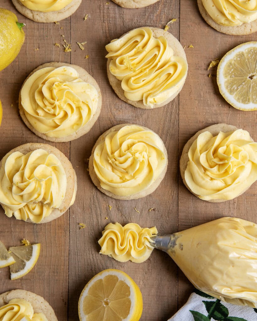 Lemon buttercream piped onto round sugar cookies.