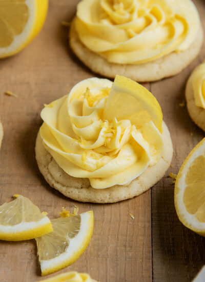 A lemon frosting topped sugar cookie, topped with a slice of lemon.