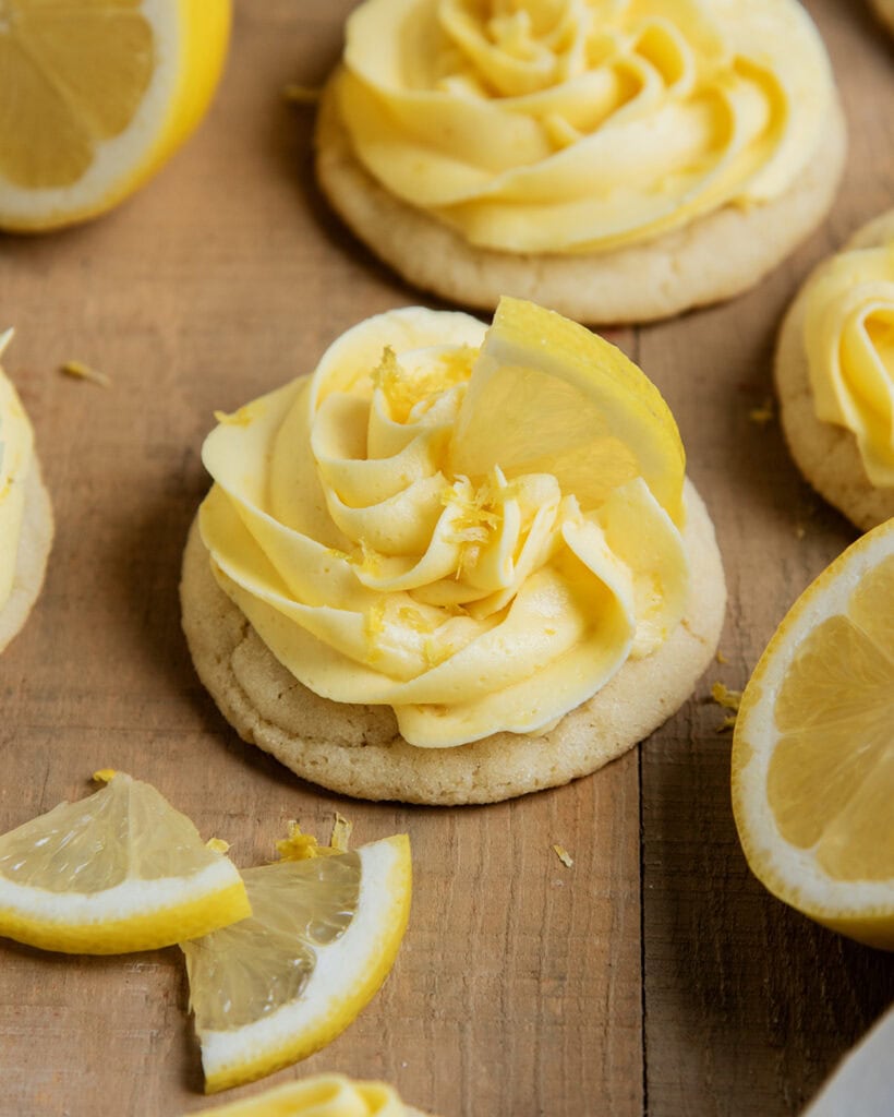 A lemon frosting topped sugar cookie, topped with a slice of lemon. 