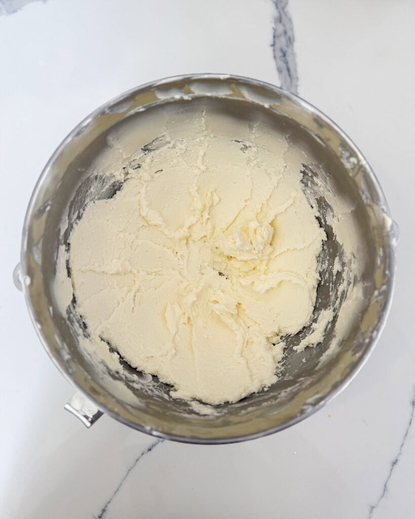 A bowl of creamed butter and powdered sugar.