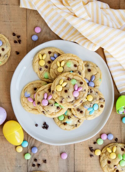 A plate of m&m cookies with mini chocolate chips and m&ms on top arraged to look like a bunny.