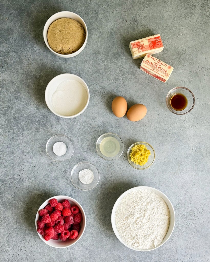 Small bowls of the ingredients needed to make raspberry lemon blondies, including brown sugar, butter, eggs, lemon zest, raspberries, and flour.