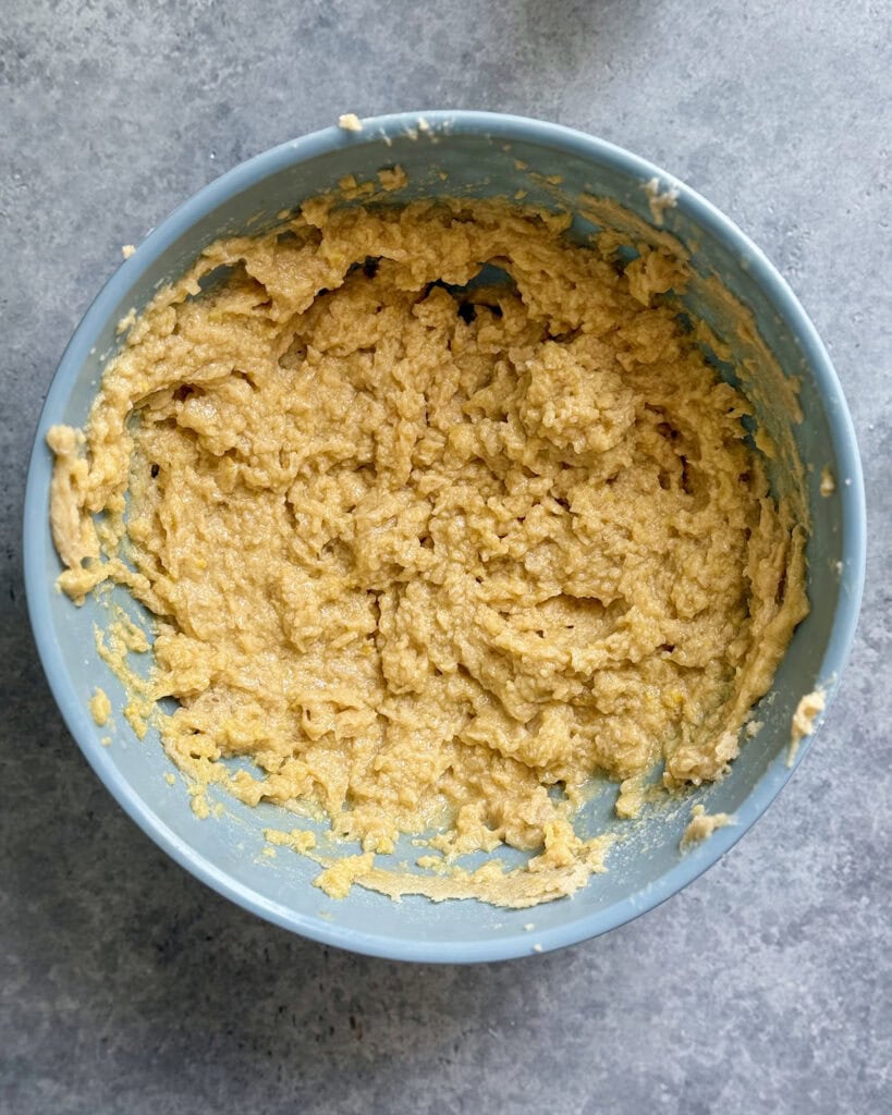 A bowl of wet ingredients to make cookies, butter, sugars, eggs, vanilla, and lemon.