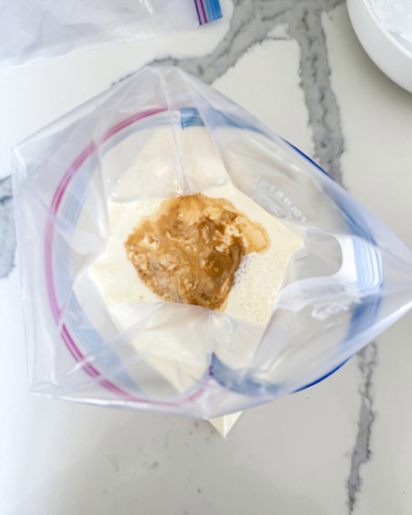A bag of cream topped with vanilla extract.