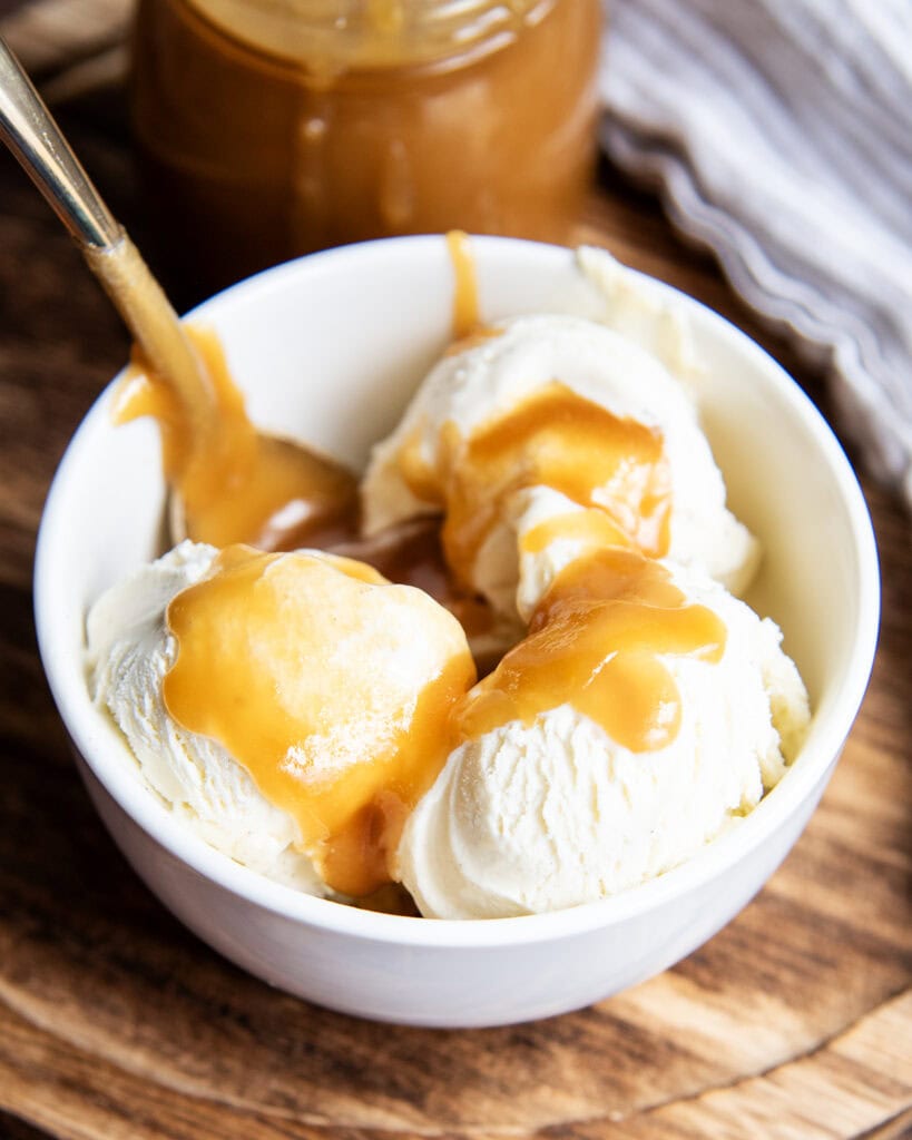 A bowl of vanilla ice cream topped with homemade butterscotch sauce.