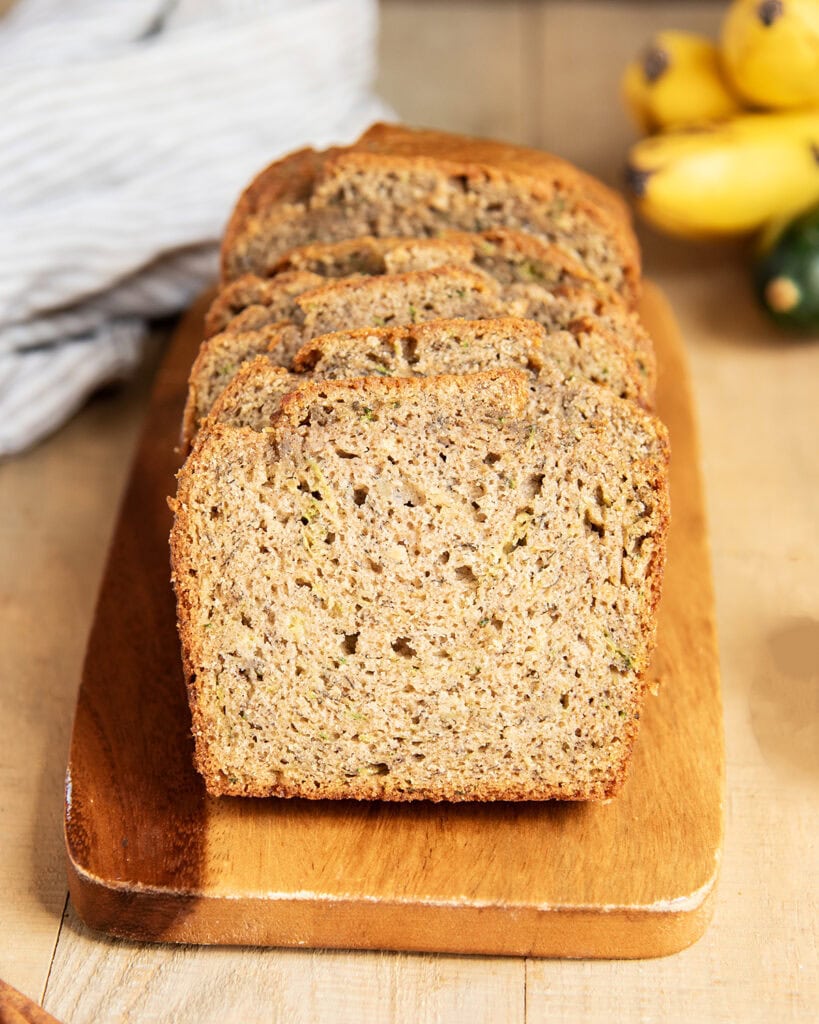 Slices of zucchini bread on a wooden board.