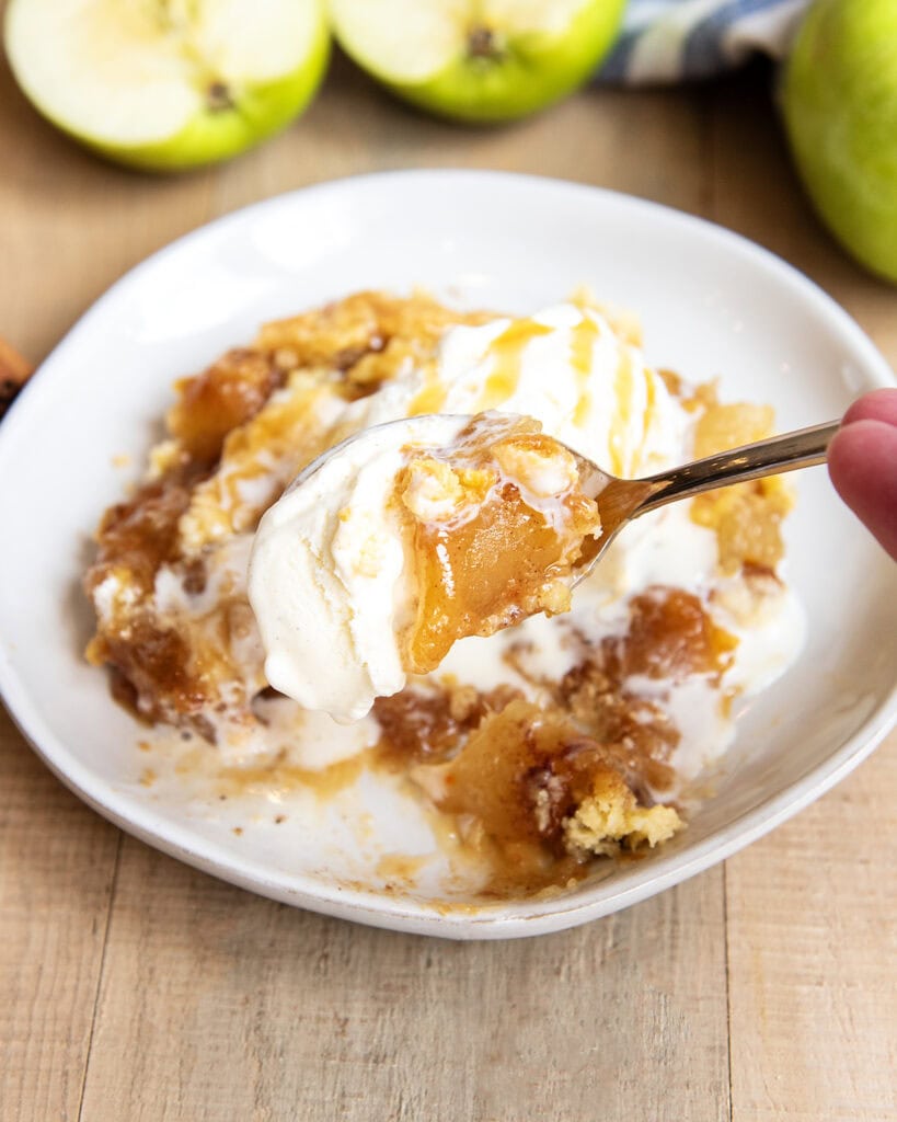 A forkful of caramel apple dump cake and ice cream. 