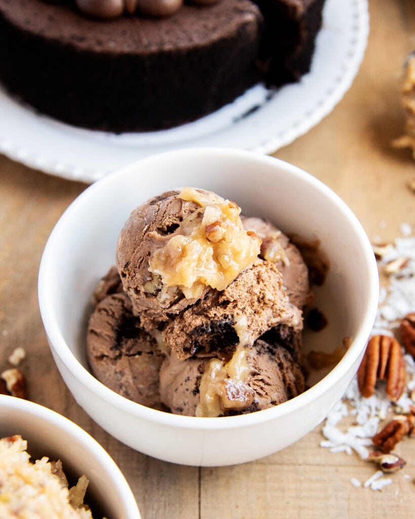 A bowl of German Chocolate Ice Cream topped with a scoop of coconut pecan frosting.