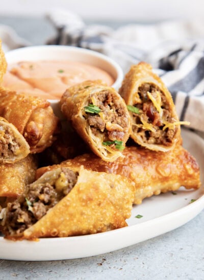A pile of cheeseburger egg rolls on a plate.