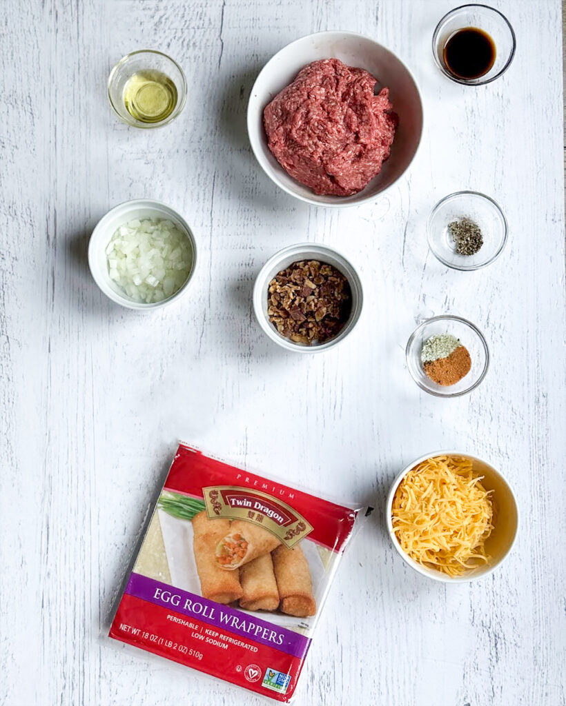 Small bowls of the ingredients needed to make cheeseburger egg rolls. 