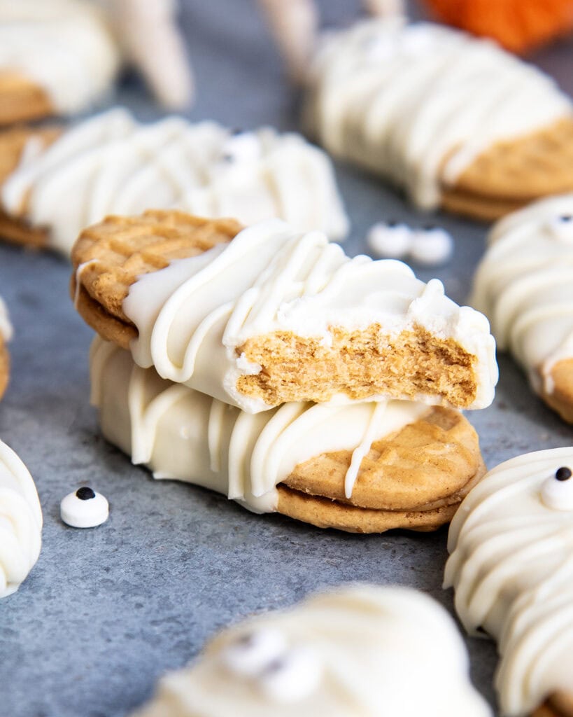 A stack of two white chocolate coated nutter butter cookies, and one has a bite out of it.