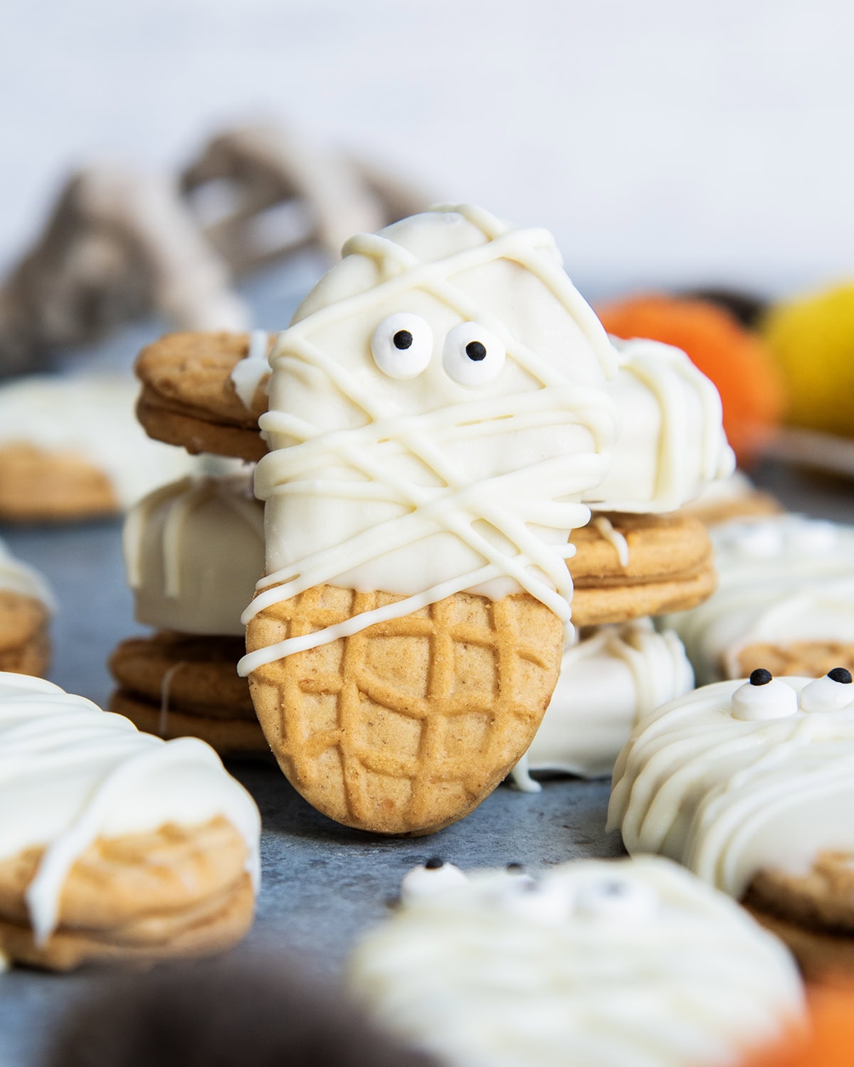 A Nutter Butter Cookie decorated with white chocolate and candy eyes to look like mummies.