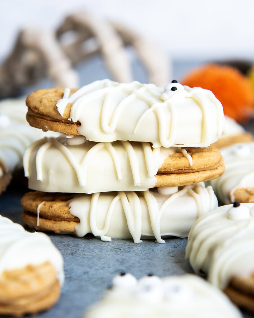 A stack of three peanut butter cookies coated in White chocolate.
