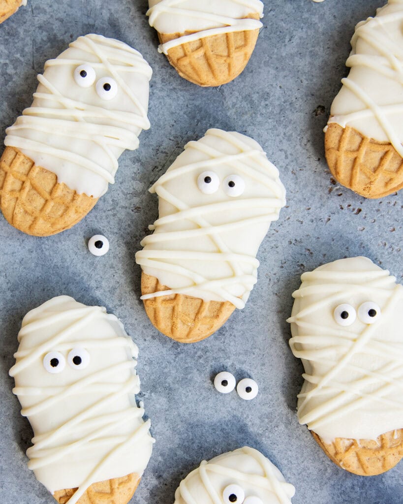 Nutter Butter Cookies decorated with white chocolate and candy eyes to look like mummies.