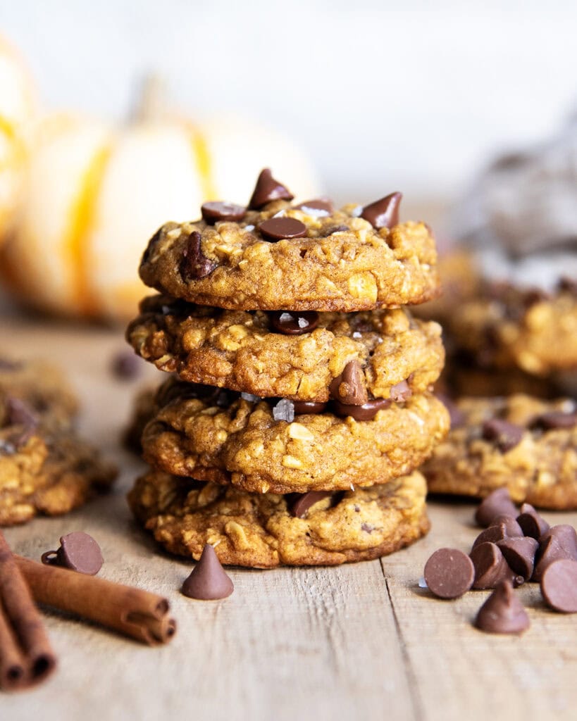 A stack of four pumpkin oatmeal chocolate chip cookies.
