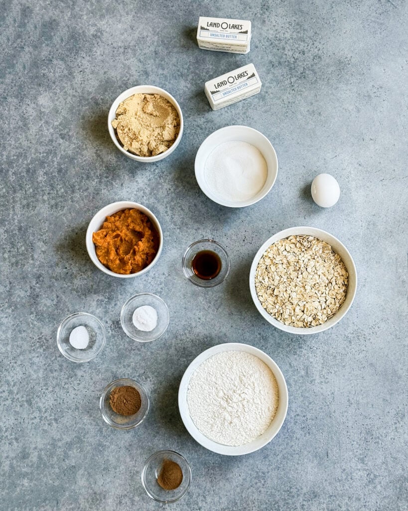 Small bowls of the ingredients needed to make pumpkin oatmeal chocoalte chip cookies. 
