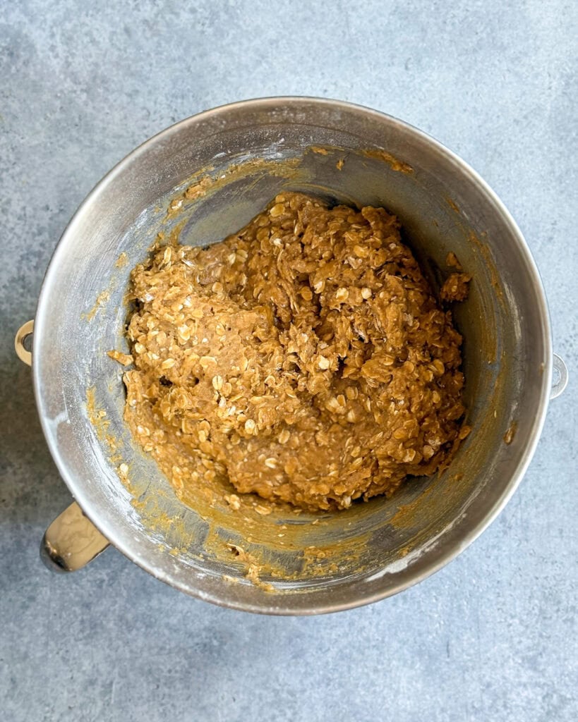 Pumpkin oatmeal cookie dough in a metal stand mixer bowl.