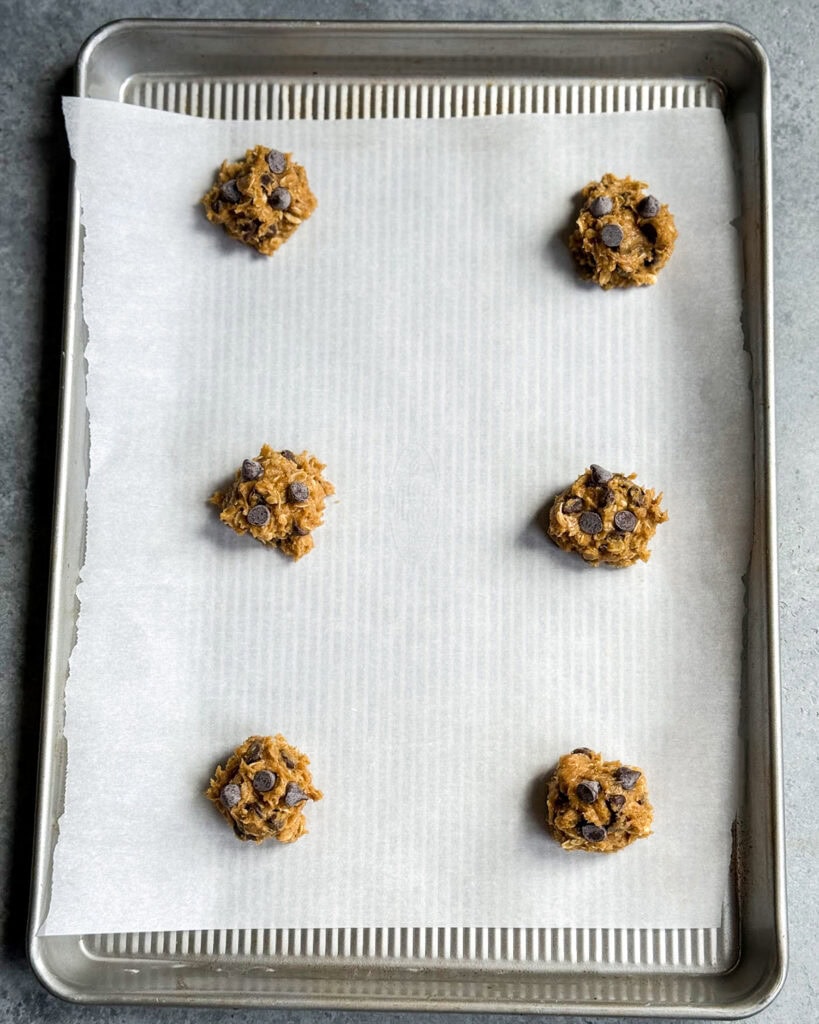Pumpkin oatmeal cookie dough in small balls on a cookie sheet.