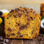 A close up of a piece of chocolate chip pumpkin zucchini bread.