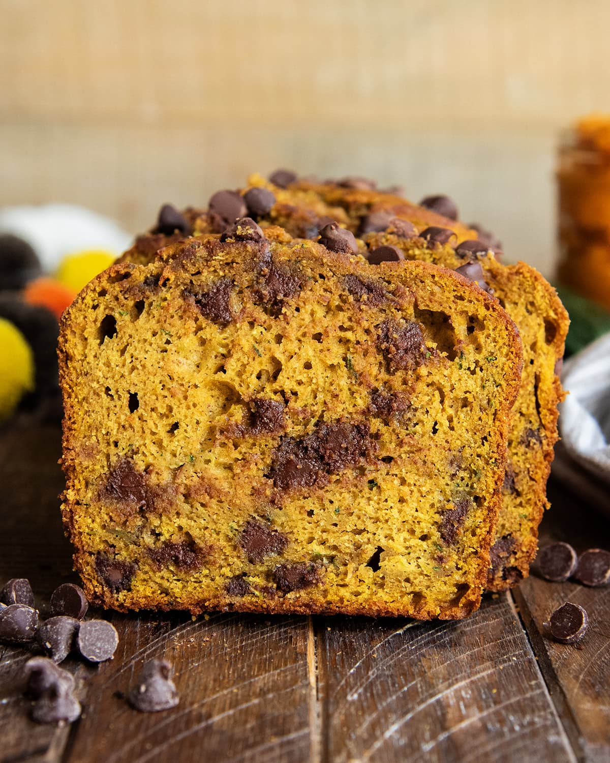 A close up of a piece of chocolate chip pumpkin zucchini bread.