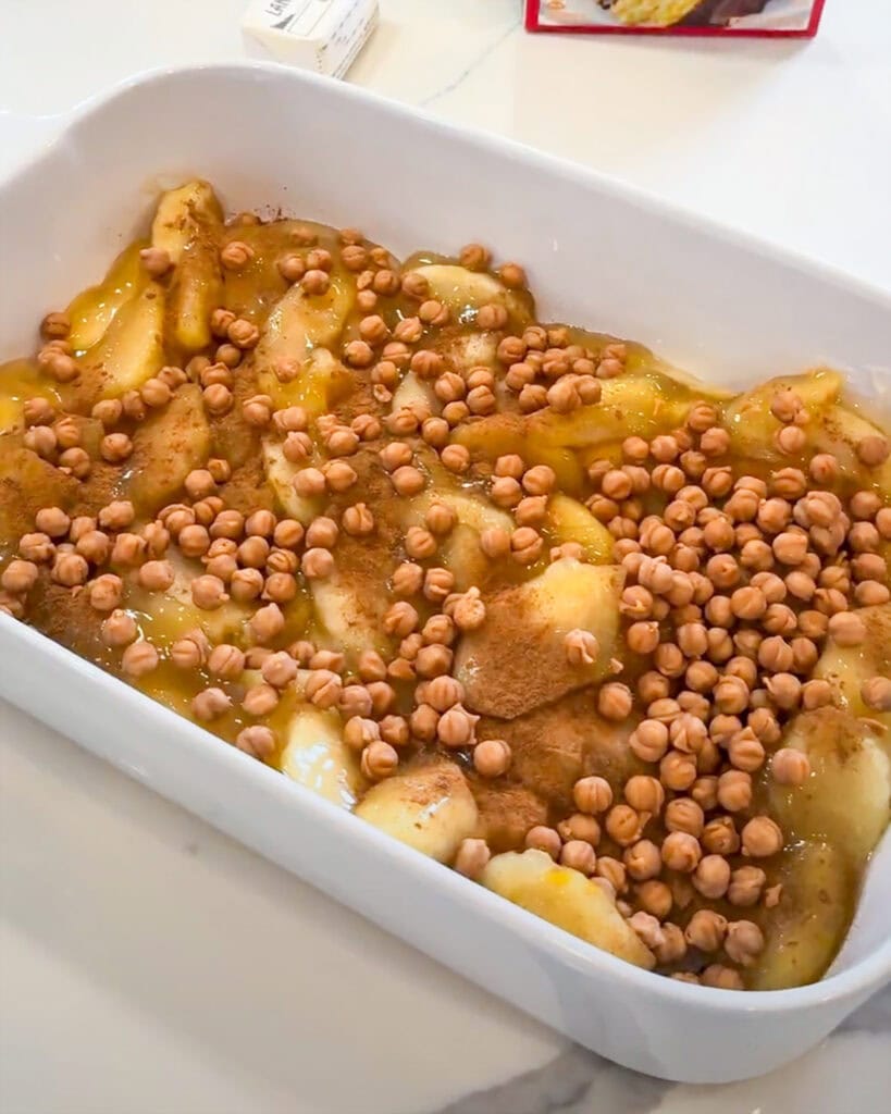 Apple pie filling in a pan topped with caramel bits.