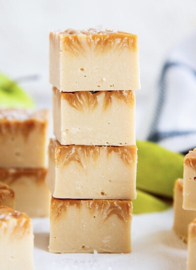 A stack of four pieces of caramel apple fudge, with caramel swirled in the top.