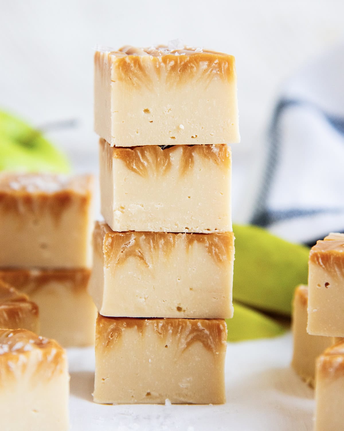 A stack of four pieces of caramel apple fudge, with caramel swirled in the top.