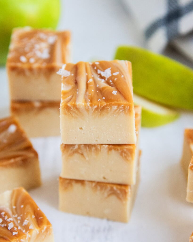 A stack of four pieces of caramel apple fudge, with caramel swirled in the top.