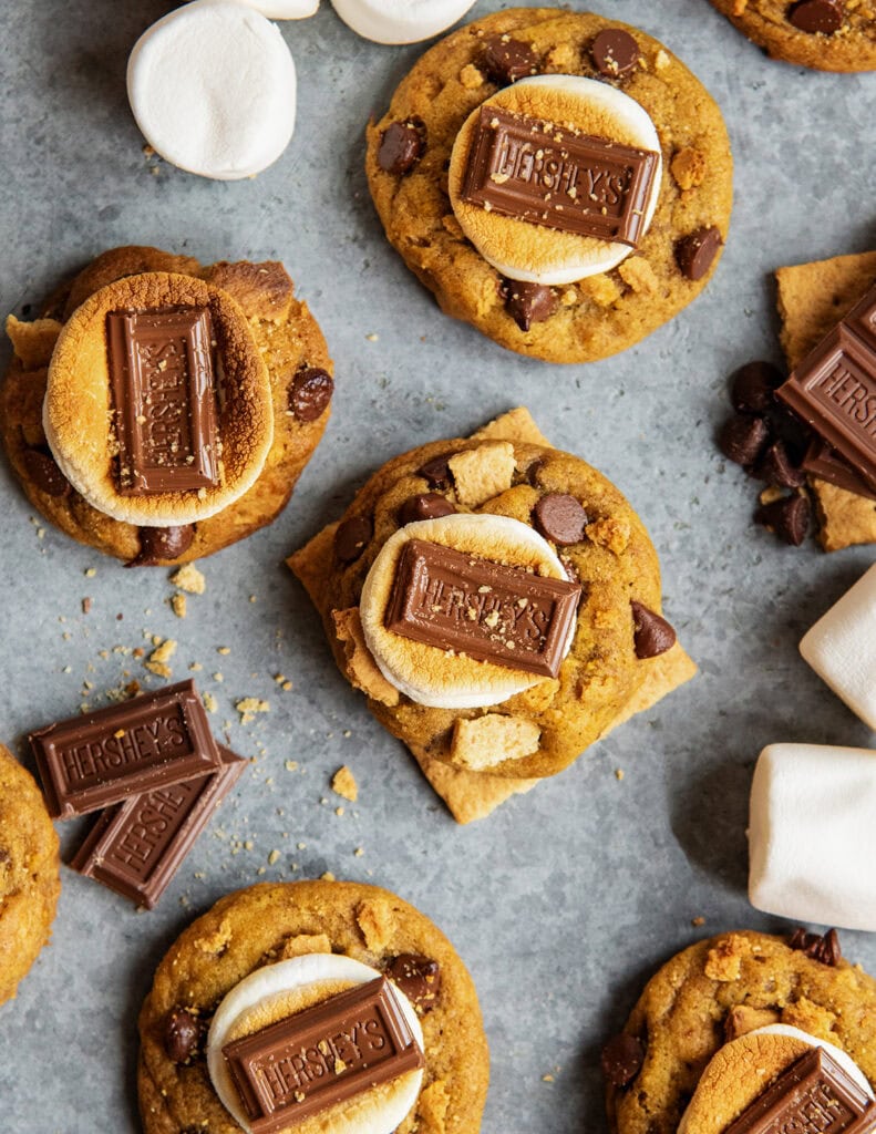 An above view of pumpkin cookies topped with a marshmallow and hershey chocolate square.