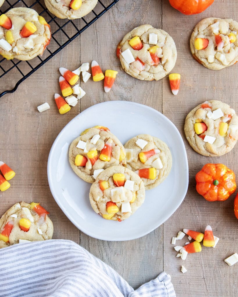 An above view of a plate of white chocolate and candy corn cookies.