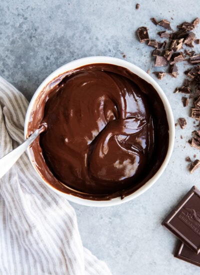 A bowl of chocolate ganache with a spoon in it.