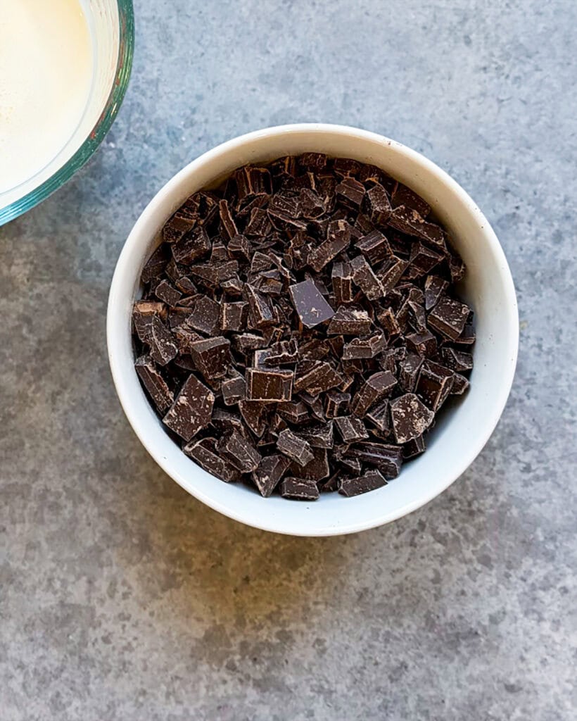 Chopped chocolate in a white bowl.