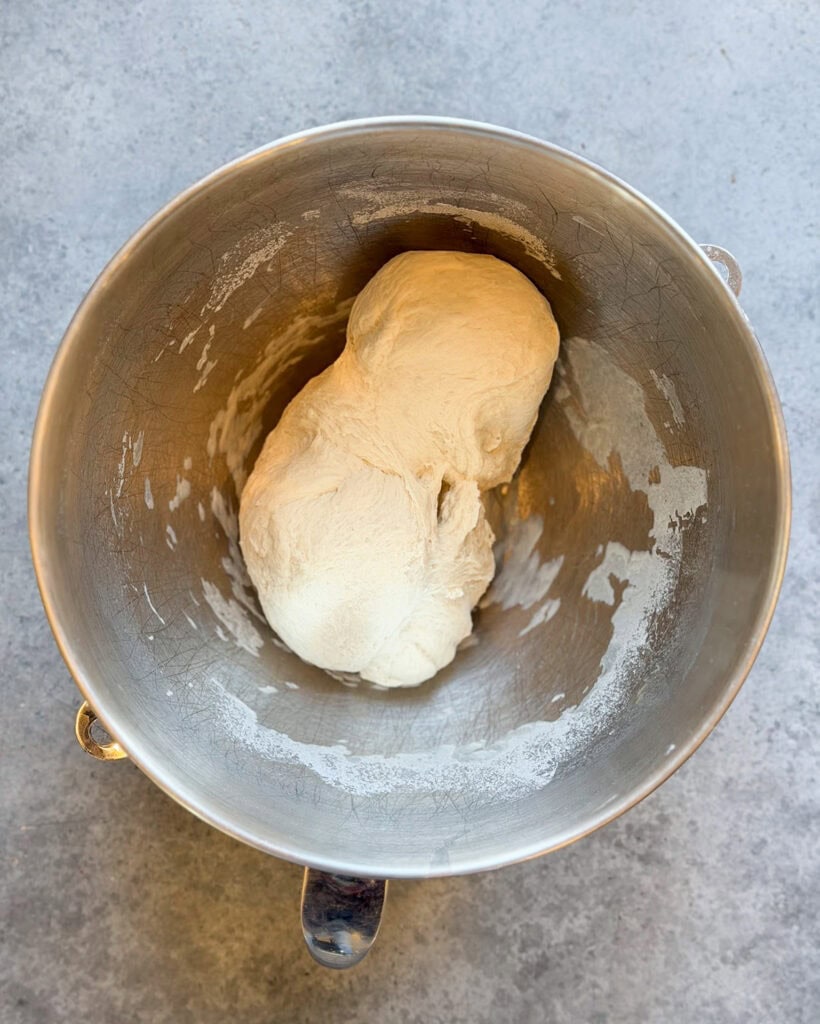 Bagel dough in a metal bowl.