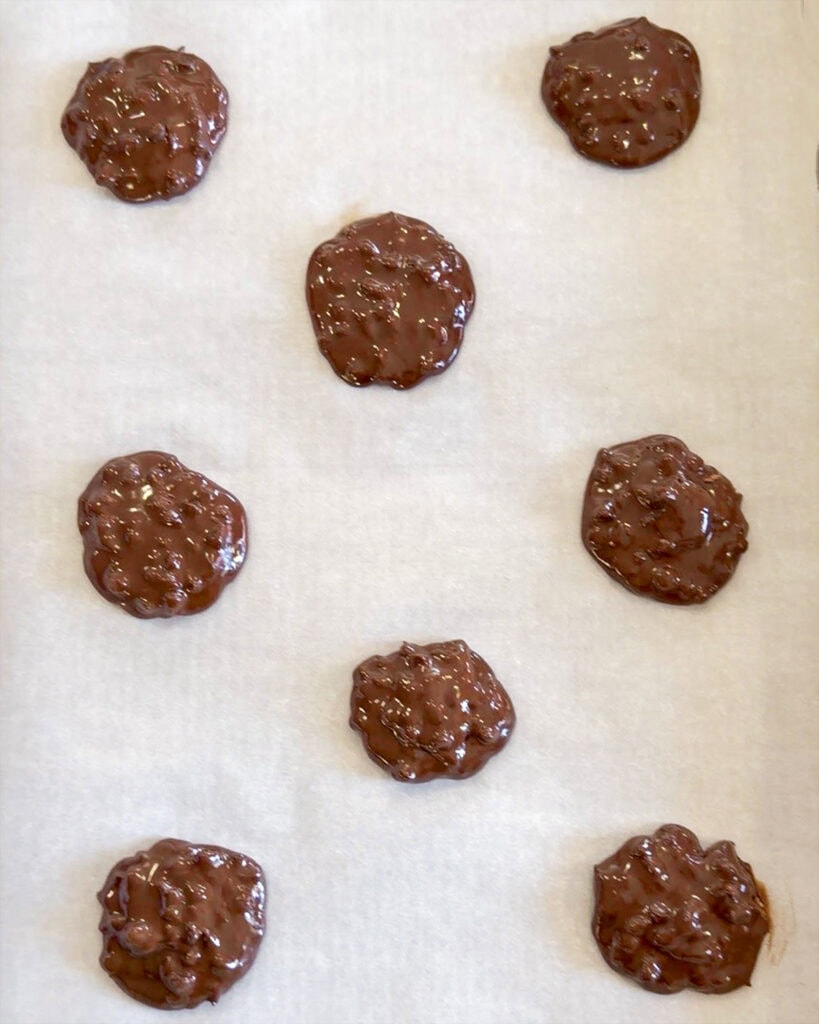 Dollops of chocolate cookie batter on a cookie sheet.
