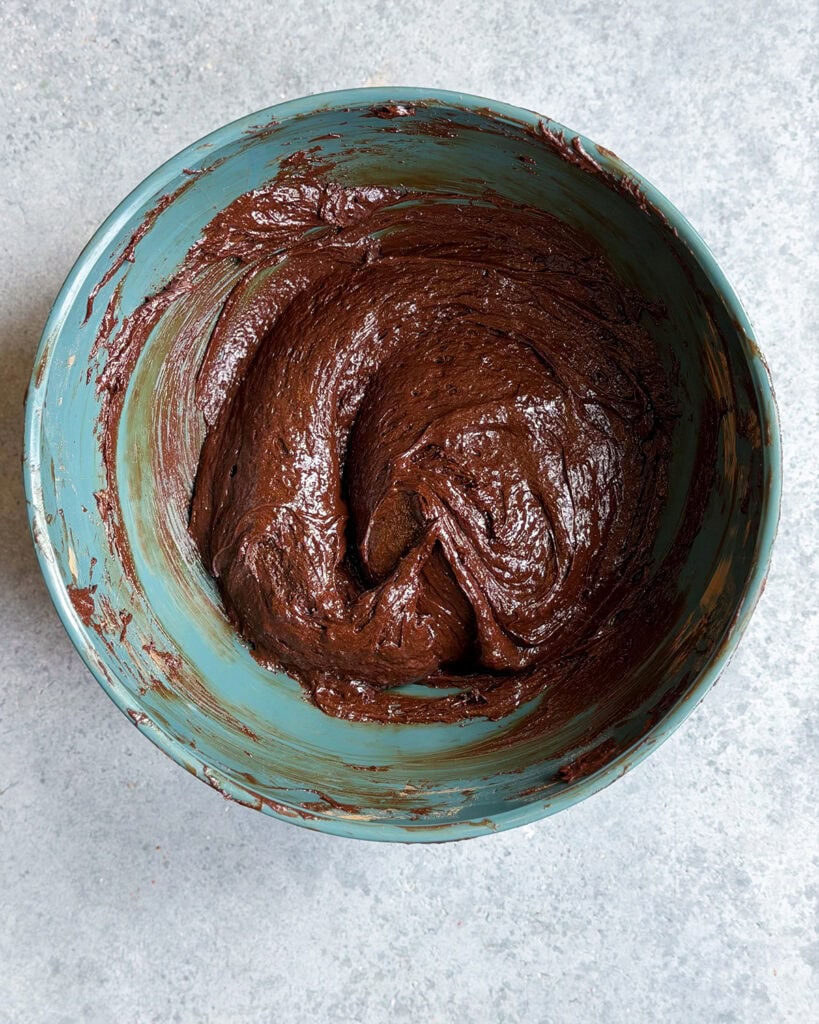 Chocolate cake batter in a teal bowl.
