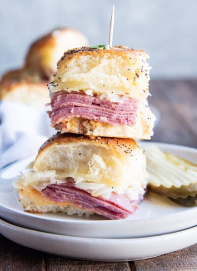 A stack of two Reuben Corned Beef Sliders on a plate.