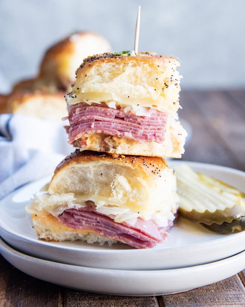 A stack of two Reuben Corned Beef Sliders on a plate. 