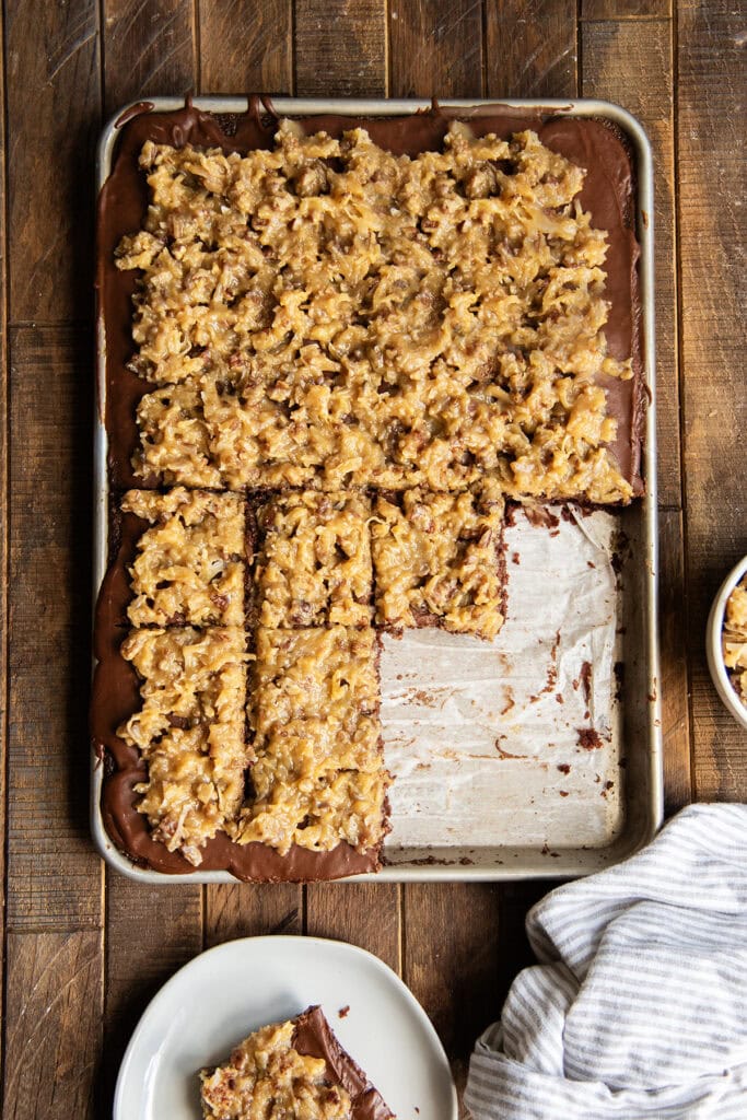 An above view of German Chocolate Texas Sheet Cake in a cookie sheet with a few pieces missing.