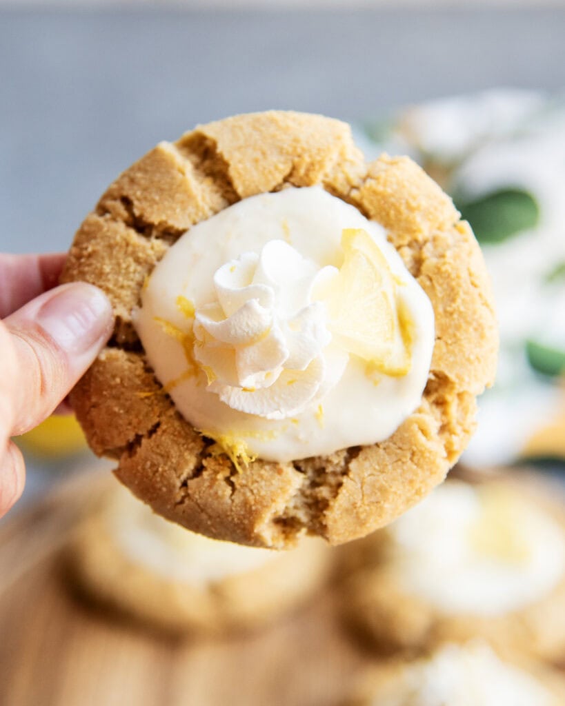 A hand holding a lemon cream pie cookie.