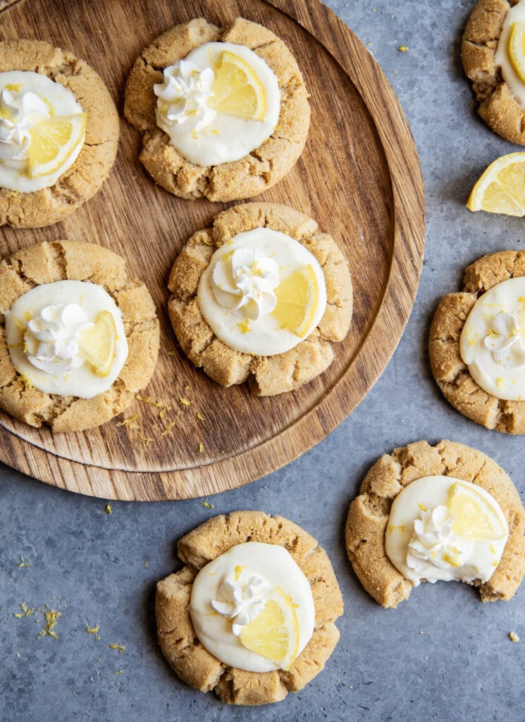 Lemon Cream pie cookies with a grahm cracker cookie base on a round wooden board.
