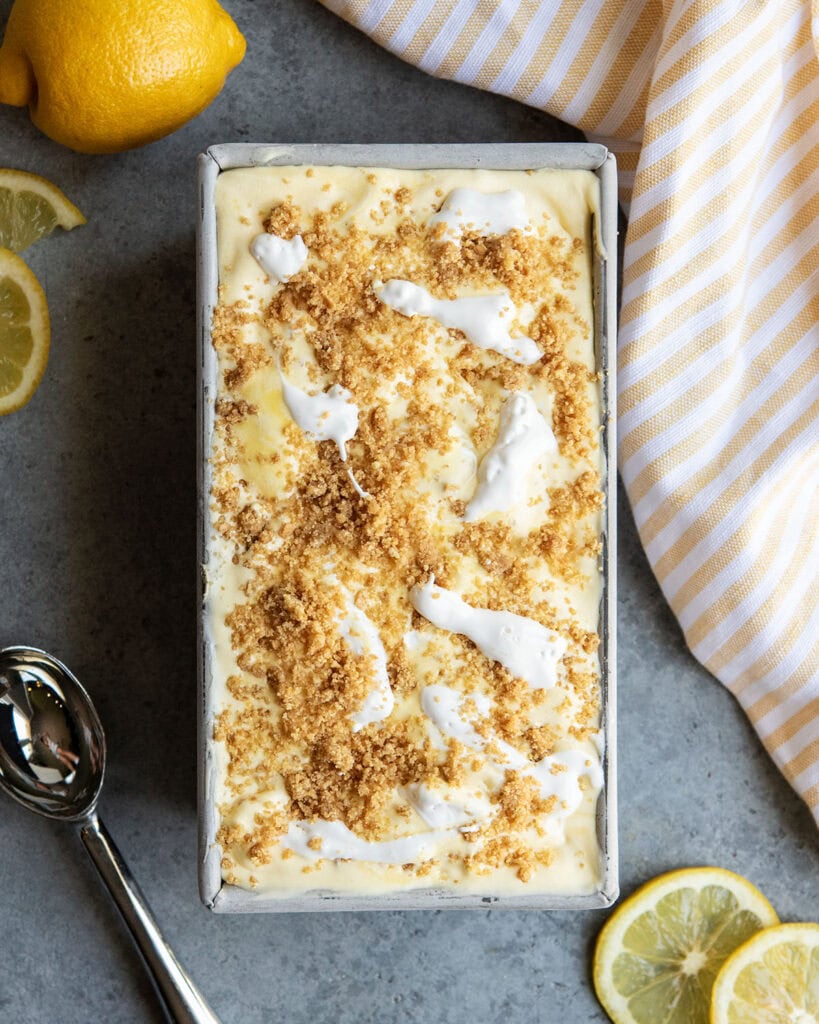 An above view of lemon cream ice cream topped with dollops of marshmallow cream and graham cracker crumble.